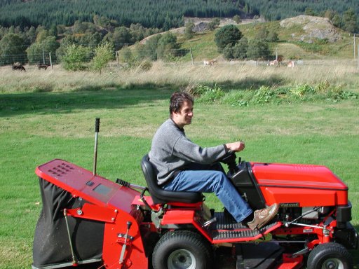 Image:  me driving a ride-on lawnmower in the grounds of the house